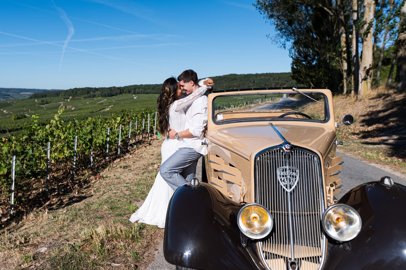 Couple de mariés près de la Peugeot 301 D dans les vignes